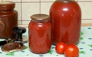 Suco de tomate espesso para o inverno em um moedor de carne