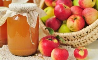 Naturlig äppeljuice för vintern från en juicepress genom sterilisering