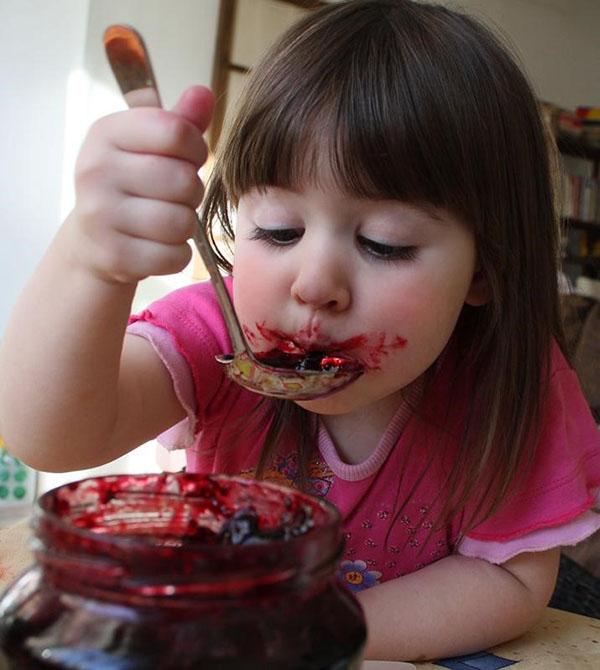 เด็กหญิงกำลังกินแยมราสเบอร์รี่